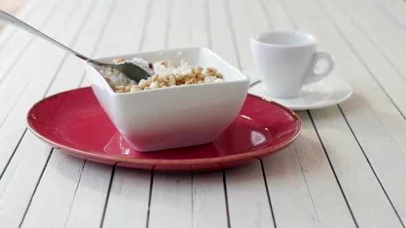 Cup with Rice on a White Wooden Background. Breakfast of Rice Porridge. Porridge in a Red Tarek on a