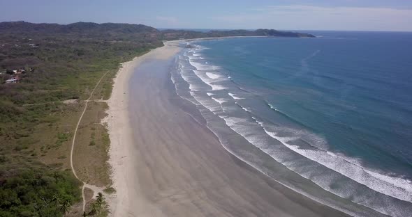 Aerial drone view of the beach, rocks and tide pools in Guiones, Nosara, Costa Rica