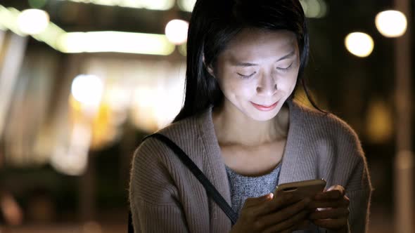 Woman watching on cellphone at night 