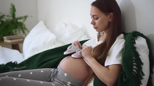 Pregnant Mother Home Hold Shoes of Unborn Baby on Belly Spbd