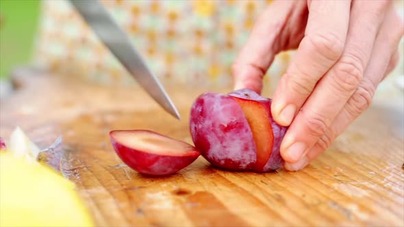 Woman cutting plum