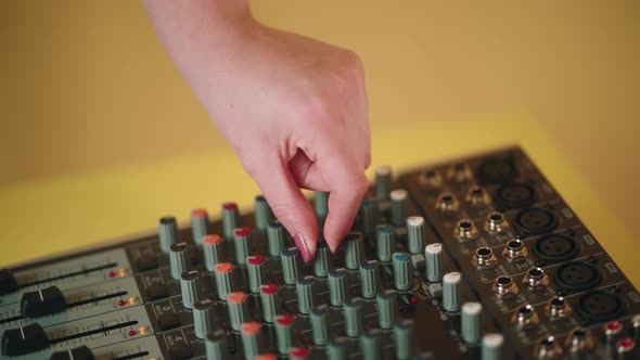 Crop faceless woman moving slider on sound console