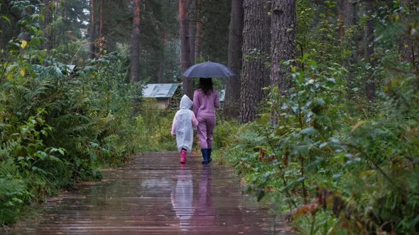Mother with Daughter Enjoying Walking in the Rain