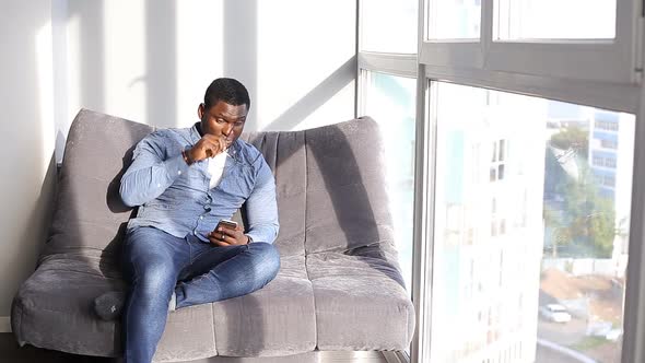 African American Man Resting on Couch.