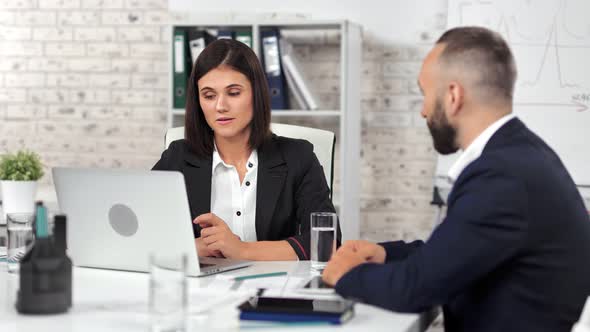 Attractive Businesswoman Talking with Male Employee Having Corporate Team Meeting at Modern Office