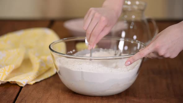 Female preparing and knead the dough in bowl