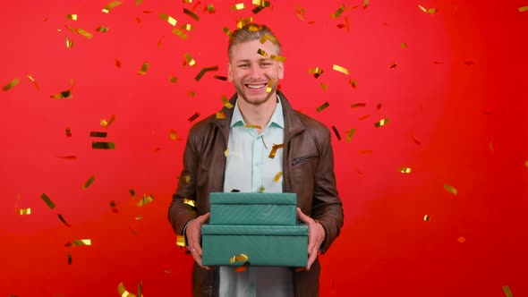 Colorful Confetti Falling Down in Front of Attractive Male with Gift Box in Hands.