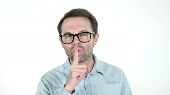 Man Gesturing Silence, Finger on Lips, White Background