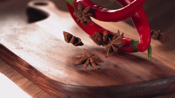 Red Chilli Pepper and Anise Falling Down on Wood