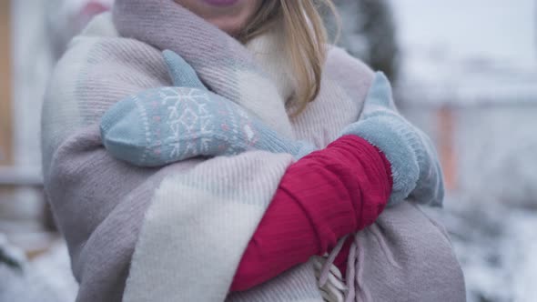 Unrecognizable Caucasian Woman in Winter Gloves and Blanket Rubbing Hands and Smiling. Cheerful