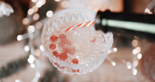 Pouring Sparkling Wine Into a Glass with Berries