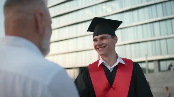 University Graduation a Father Embraces His Son a University Graduate Young Man in a Graduate's Robe