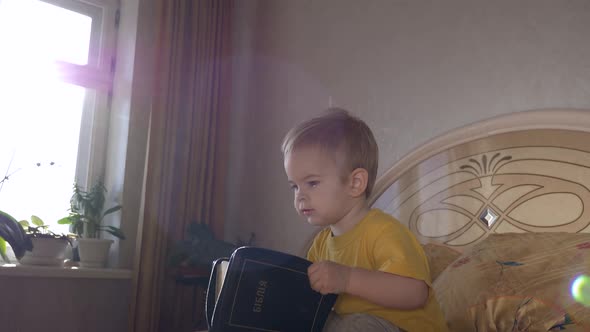 Little Child Sits On The Bed With Bible 7