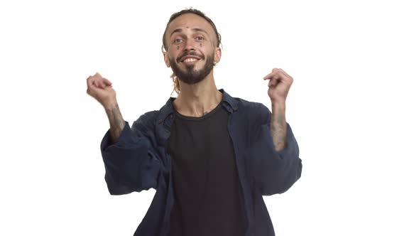 Handsome Caucasian Man with Tattoos on Face and Body Pointing Fingers at Camera and Nodding Pleased