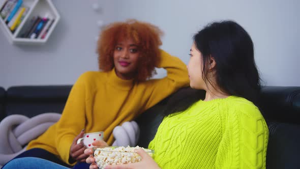 Multiracial Friendship. Afican American Black and Asian Woman Eating Popcorns Gossiping and Watching