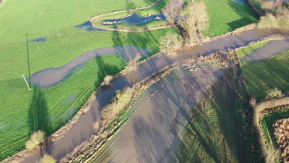 Aerial footage of the British country side fields in the winter time showing a river in the UK