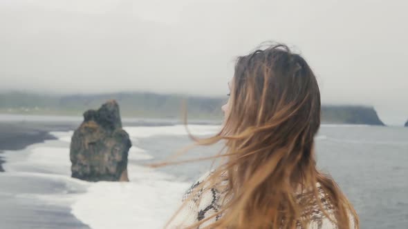 Beautiful Sad Woman Thinking on the Black Beach in Iceland, Troll Toes Rocks and Wave on the