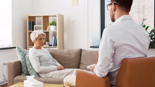 Senior Woman Patient Talking To Man Psychologist