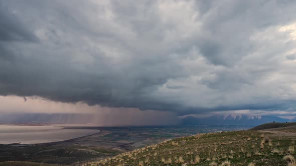 Rainstorm moving over Utah Valley with thick dark clouds in timelapse