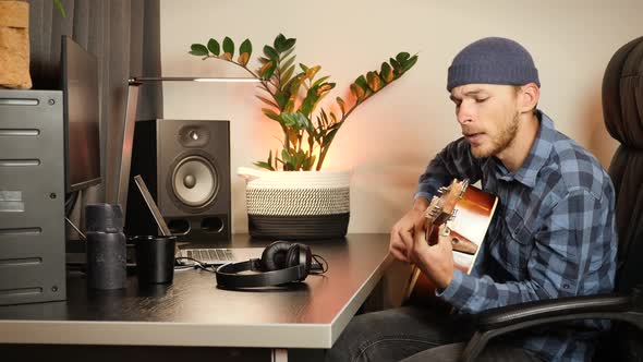 Talented young guy singing song and playing acoustic guitar.