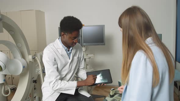 African American Family Medical Doctor in Modern Clinic Holding Tablet Pc and