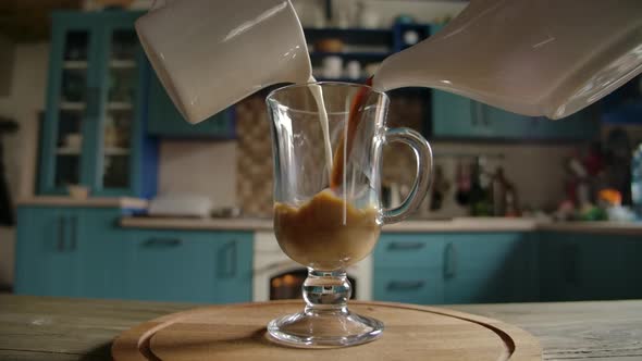 black aromatic coffee and white fresh milk are poured into transparent glass mug