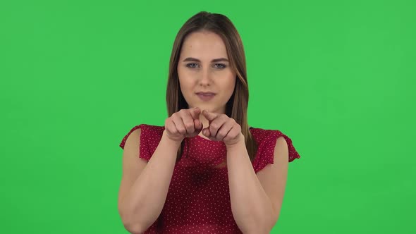 Portrait of Tender Girl in Red Dress Is Smiling and Showing Heart with Fingers Then Blowing Kiss