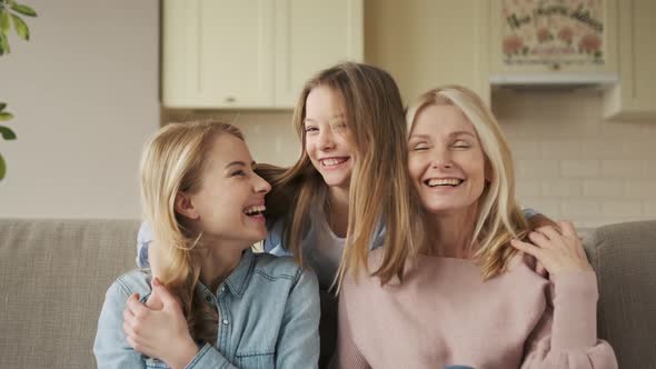 Three Generations of Women Look at Camera Cute Little Girl Hug Mom and Granny Enjoy Time at Home