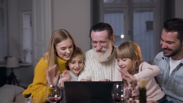 Family with Grandfather Sitting at the Festive Table and Having Video Chat Via Messenger App