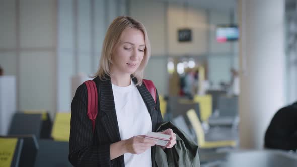 An Attractive Young Woman at the Airport is Waiting for Her Departure