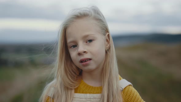 Portrait of Female Child with Natural Blond Hair Outdoors
