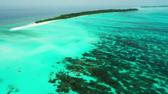 Aerial flying over scenery of idyllic tourist beach lifestyle by blue water with white sandy backgro