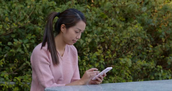 Woman use of mobile phone in picnic area