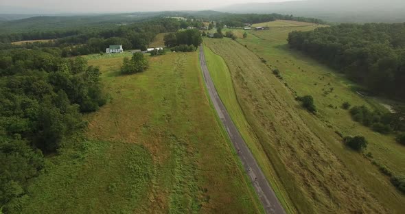 Aerial views of family bicycling along pastoral country roads.