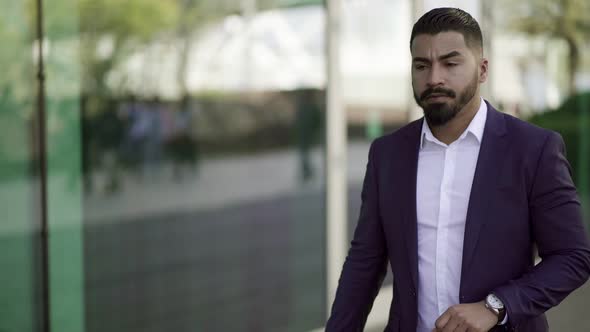 Serious Businessman Checking Wrist Watch on Street