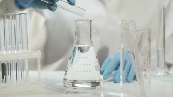 Chemist Adding Substance Into Conical Flask With Liquid, Chemical Experiment