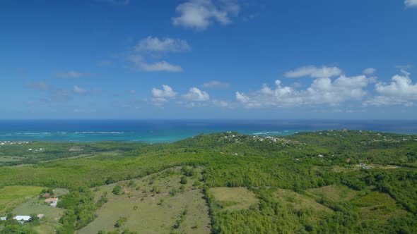 Aerial of green rolling landscape overlooking sea