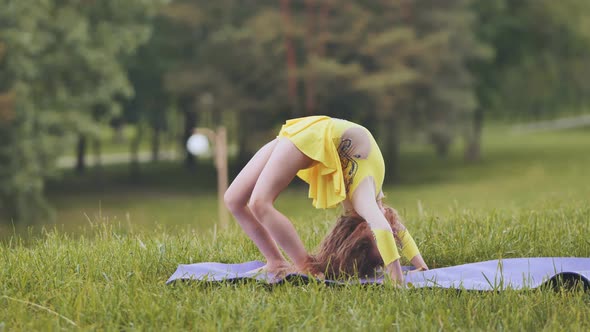 A Little Girl Performs the Elements of Rhythmic Gymnastics in the Park