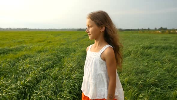 Little Girl Standing on the Green Grass. Cute Child Dreaming on the Nature