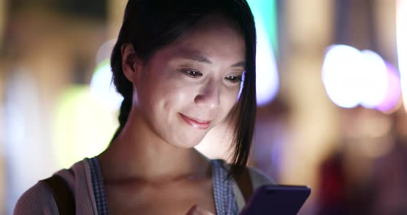 Woman use of mobile phone in city at night