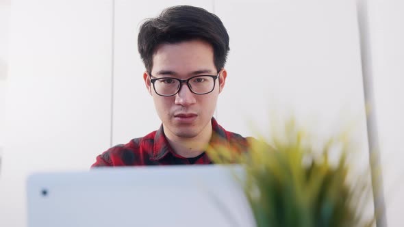 Portrait of Young Asian Man Using Laptop To at Home