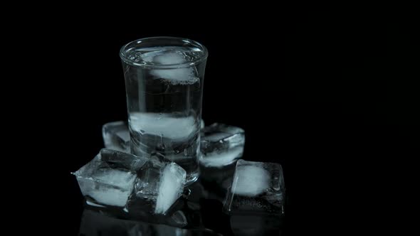 Alcohol with ice cubes on a black background.