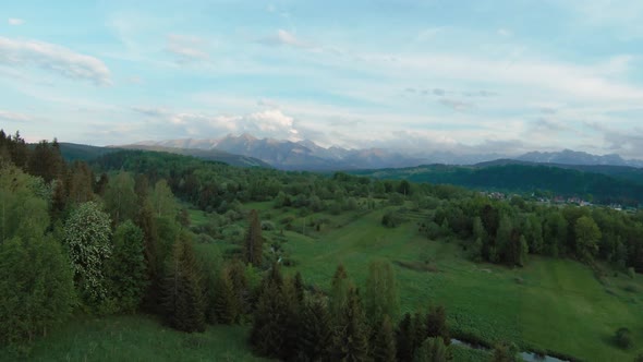 Aerial View of a Mountain Landscape with Rocky Peaks on the Background