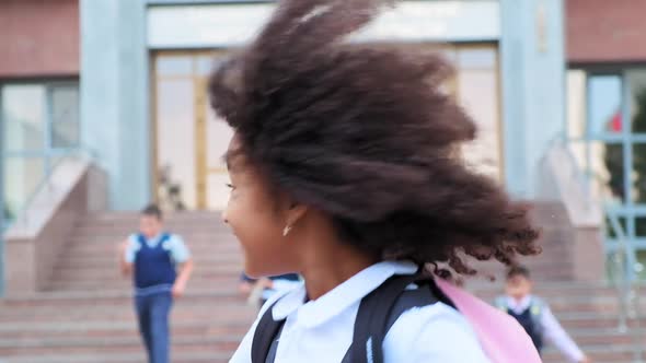 African-American Student in Uniform Runs Along School Yard