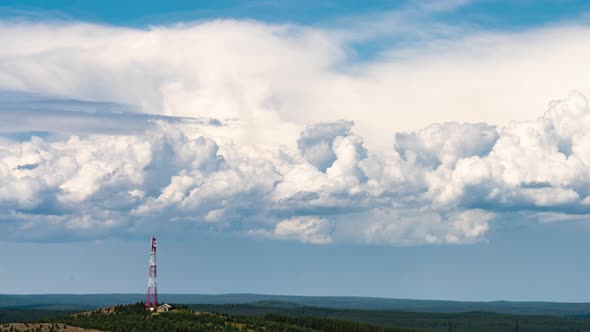 Movement of Cumulus Clouds Behind a Hill with a TV Tower on Top