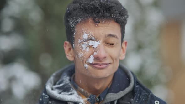 Snowball Hitting Face of Smiling Middle Eastern Young Man in Slow Motion