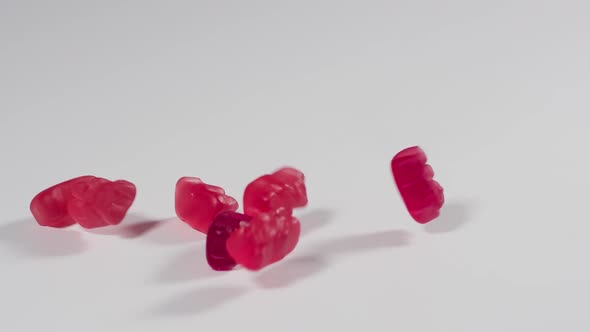 Gummy Bears falling onto a white surface in slow motion