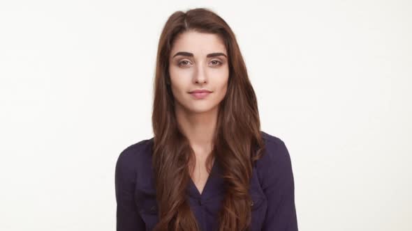 Young Attractive Caucasian Female in Dark Blue Shirt with Long Brown Hair Showing Ok and Winking on