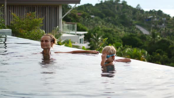 Mom and Daughter Swim in the Pool