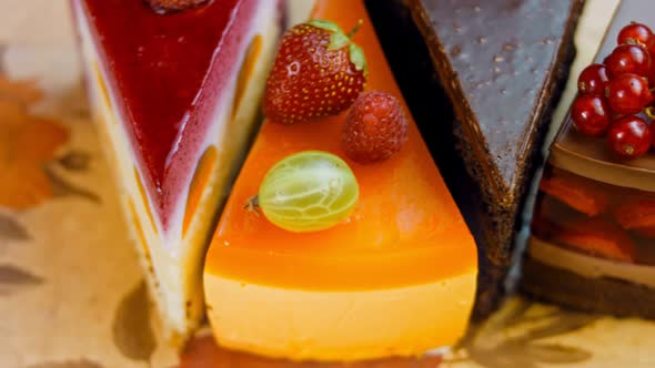 A Few Slices of White and Red Strawberry and Cherry Cake and Chocolate in an Open Box